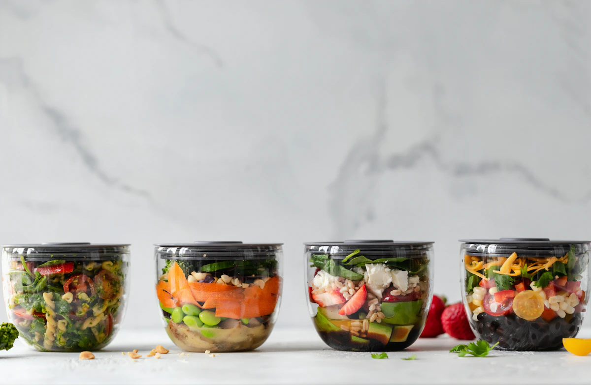 Quatre contenants transparents remplis de salades composées