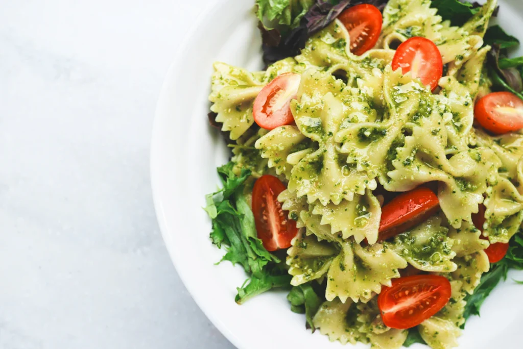 Salade de pâtes au pesto avec tomates cerises et feuilles vertes